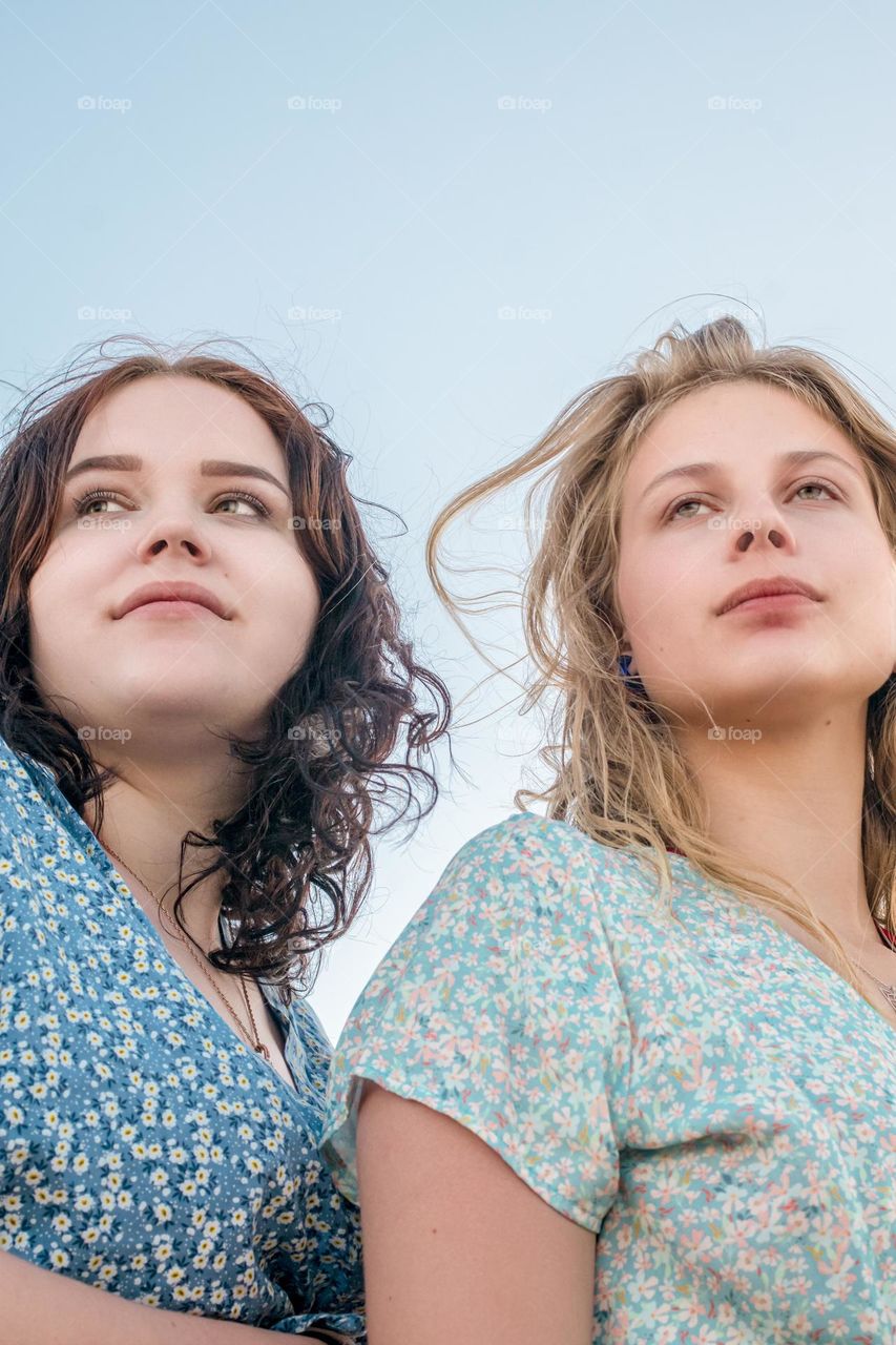 portrait of two sisters on the beach in the summer