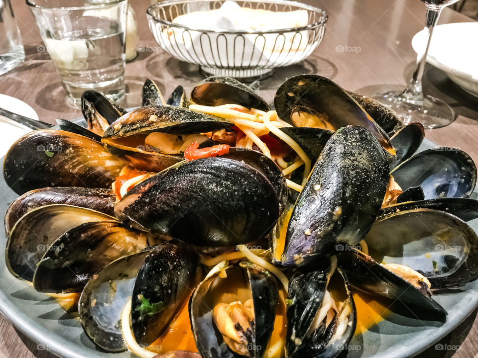 Fresh muscles over pasta, restaurant dining dish closeup