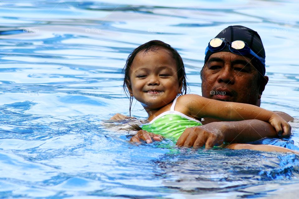 a father and child in a swimming pool