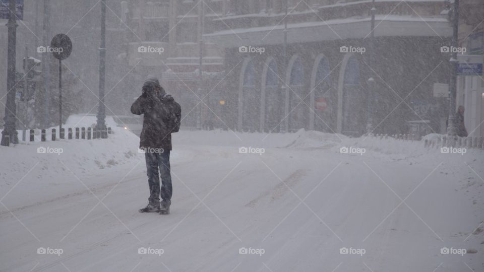 Photographer under the snow downtown in Bucharest