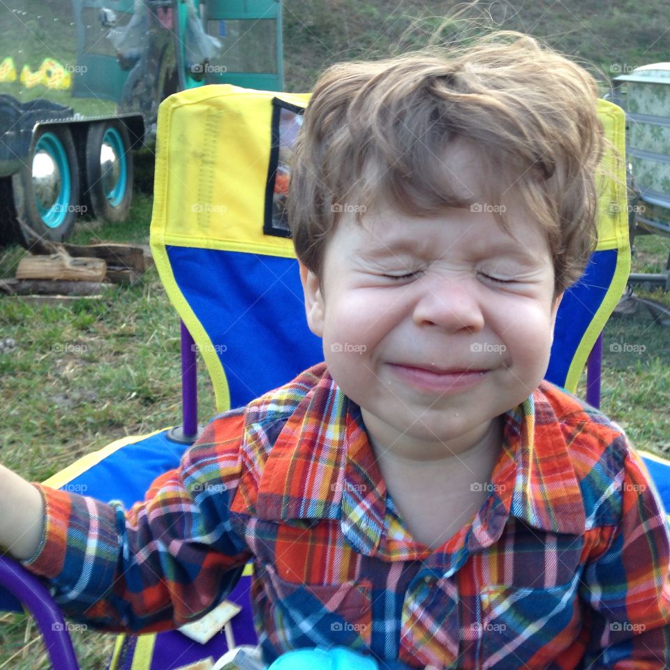 Little boy making funny face with closed eyes