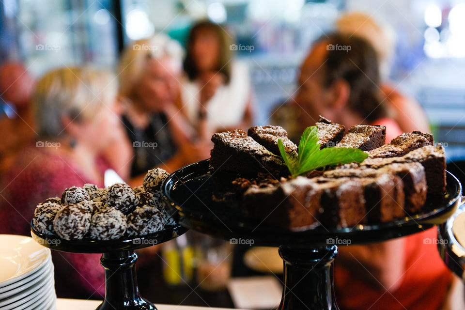 Cake at a local cafe with people and guests in the background.