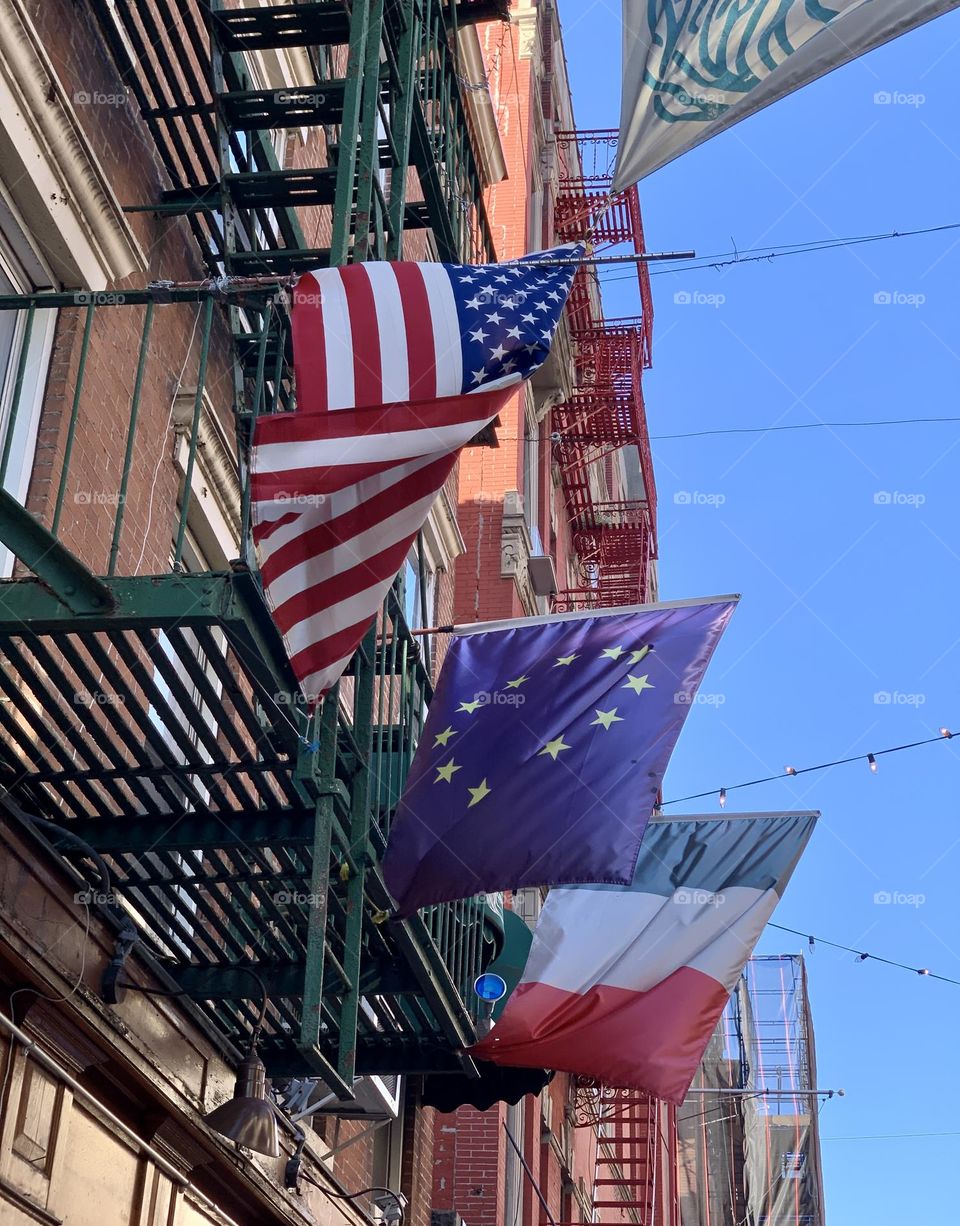 American and Italian Flag on the side of the apartment building. China Town New York.