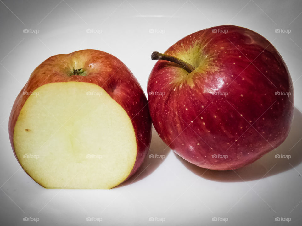 Healthy fruit Apple with dark maroon colour and Half cutted Apple.