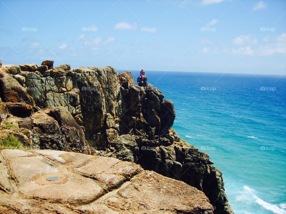 Man sits on a cliff on Frazer island in Australia