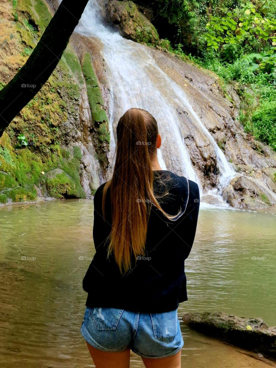 the girl admires the silence of the Buraul Mare waterfall