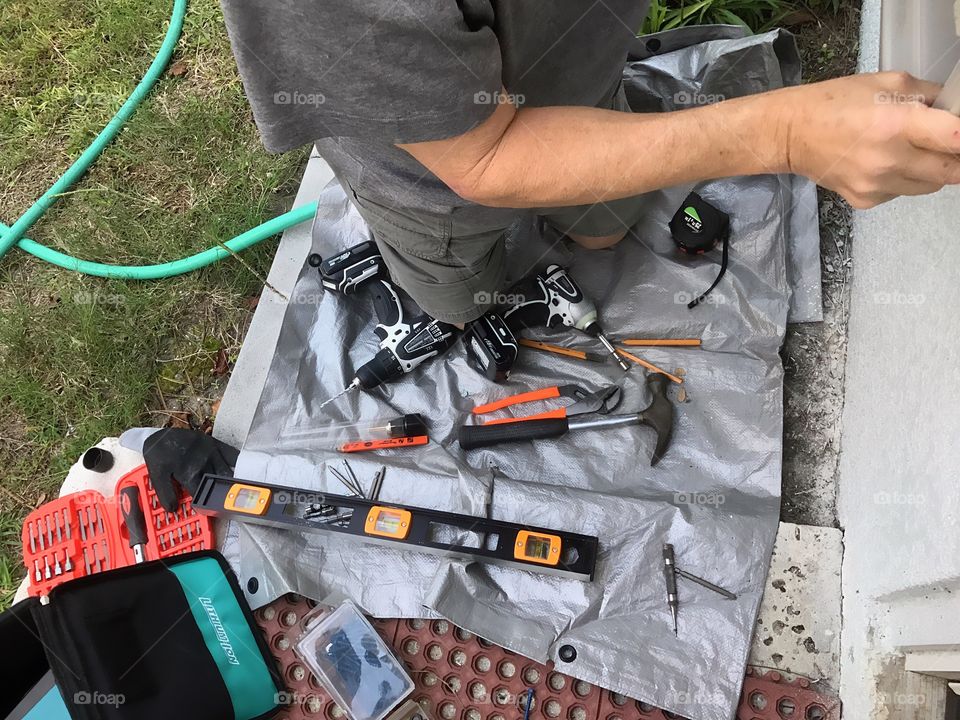 Man busy with home repair with his favorite gadget.