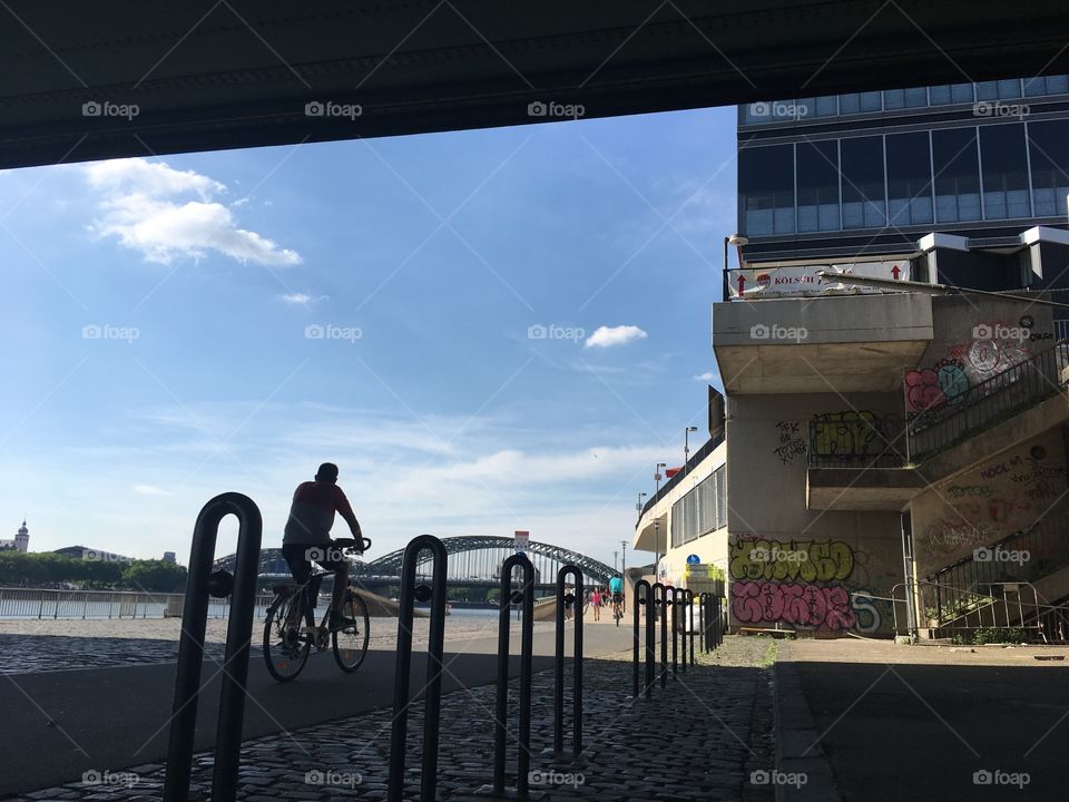 An urban scene in Cologne, Germany. A bike is crossing the hot Summer scenery.