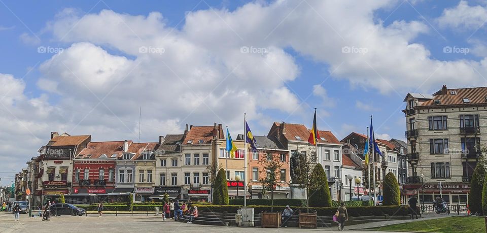 Beautiful panoramic view of the Belgian houses, flags and square on a clear sunny day in the center of the Anderlecht district in Brussels, close-up side view.