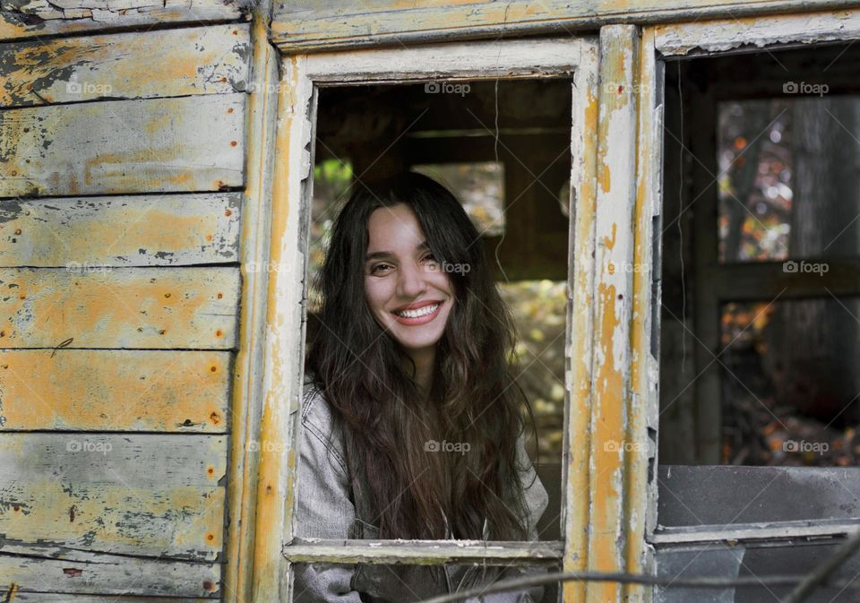 Beautiful smiling woman in country home window