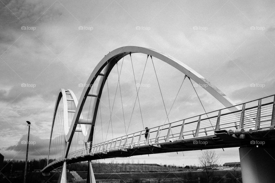 Alone on the Bridge . A man gazes up the River Tees from the Infinity Bridge in Stockton, England. 
