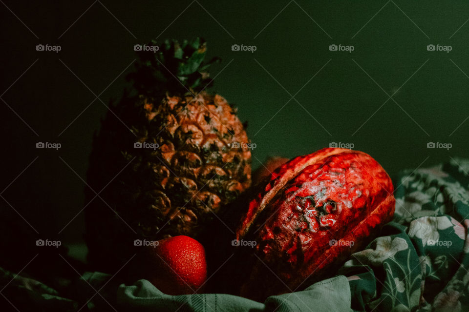 Hawaiian Pineapple and a Cacau Fruit skin with colorful lighting. Details of fruit skin, creamy Bokeh