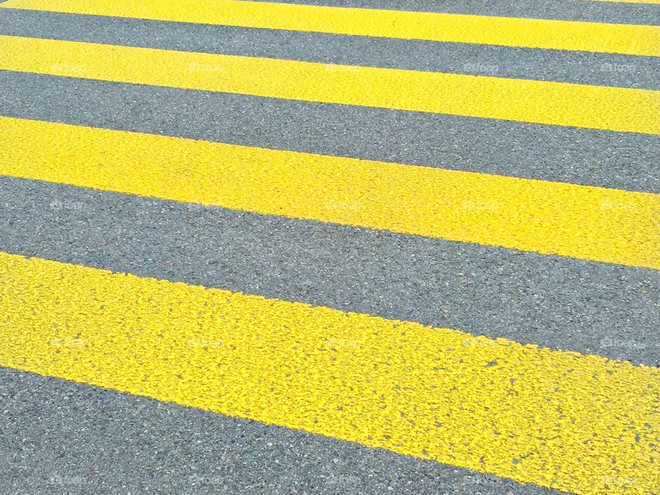 Yellow stripes. Yellow stripes on the street, waiting for someone to cross.