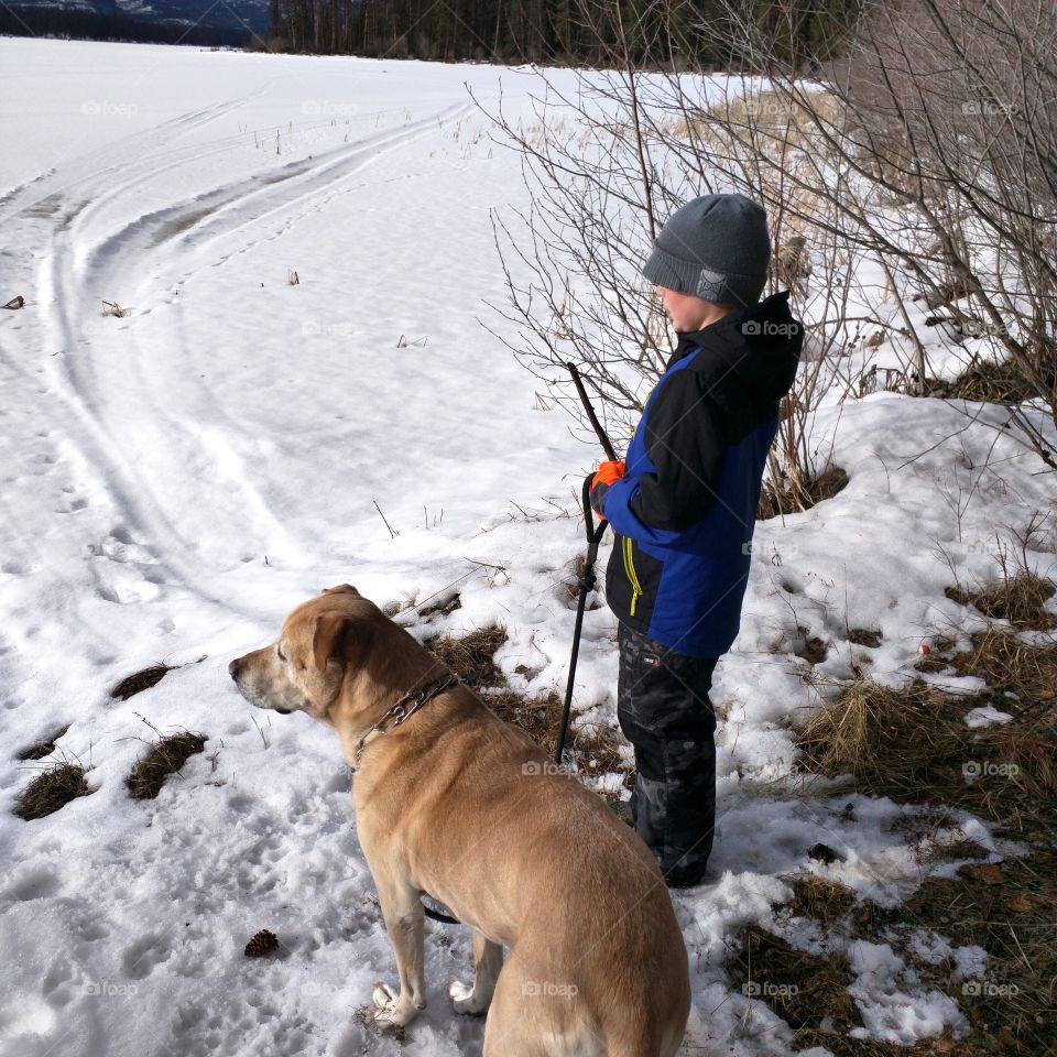 A boy and his dog at the lake in Winter