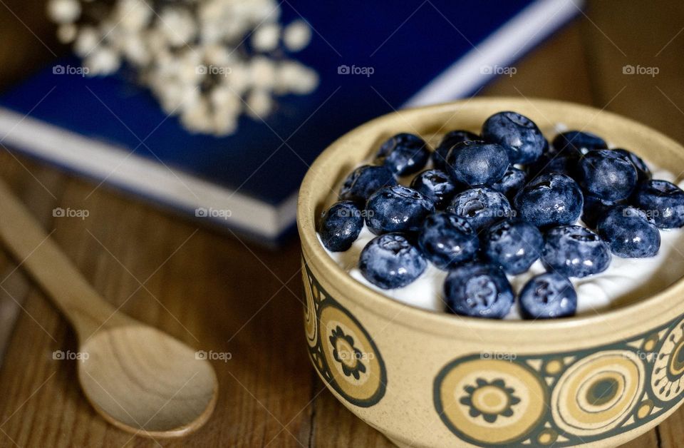 Blueberries in yoghurt in a retro yellow bowl