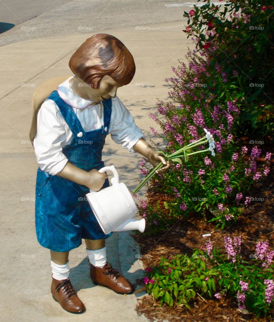 Sculpture of a girl watering plants in Carmel Arts & Design District in Carmel, Indiana 