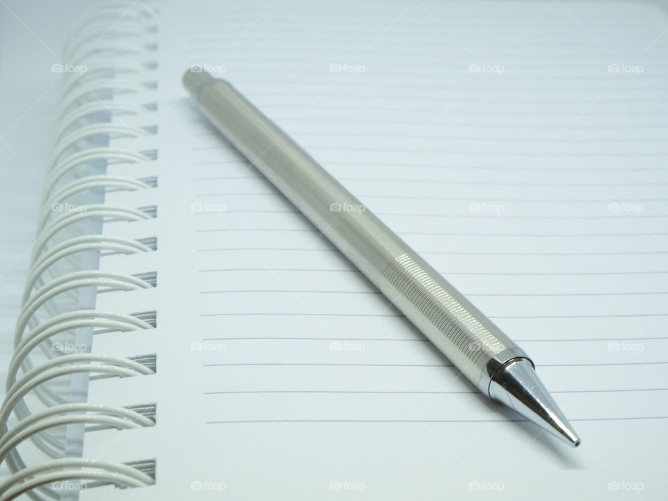 silver pen on the book,notebook and silver pen,empty notebook with pen