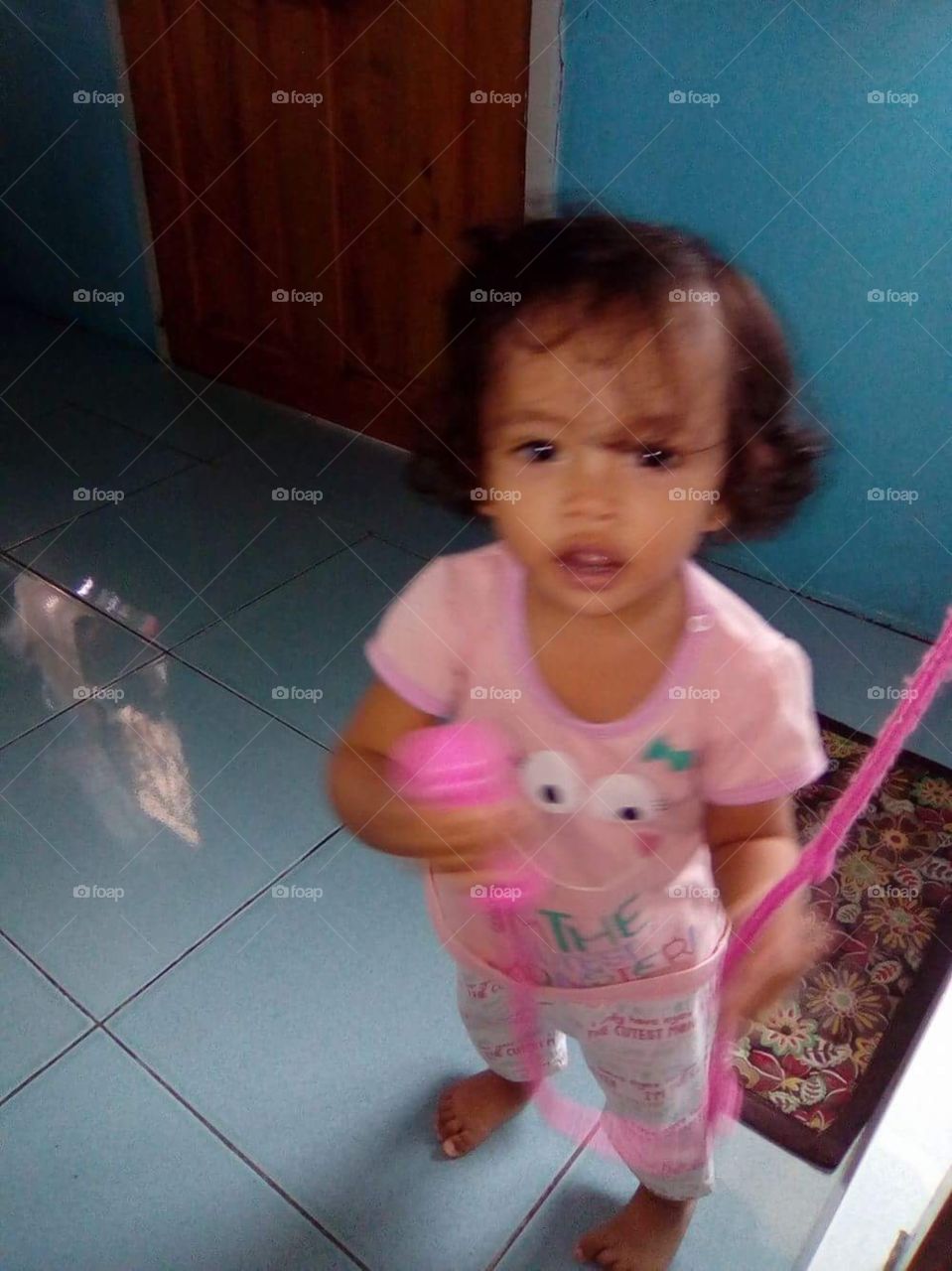 Our one year old daughter with her pretend microphone singing her first song.