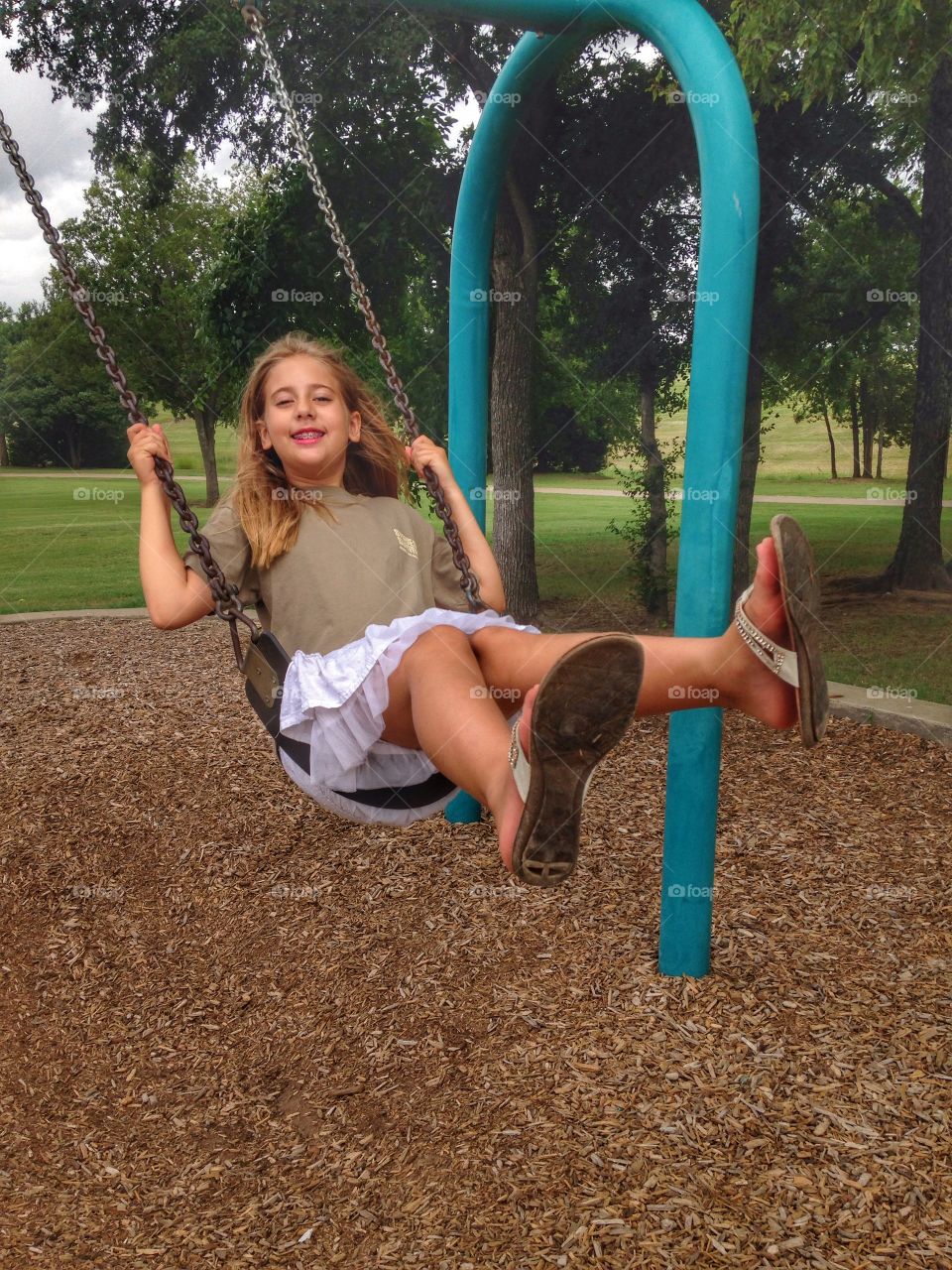 Push me higher. Girl swinging at the park