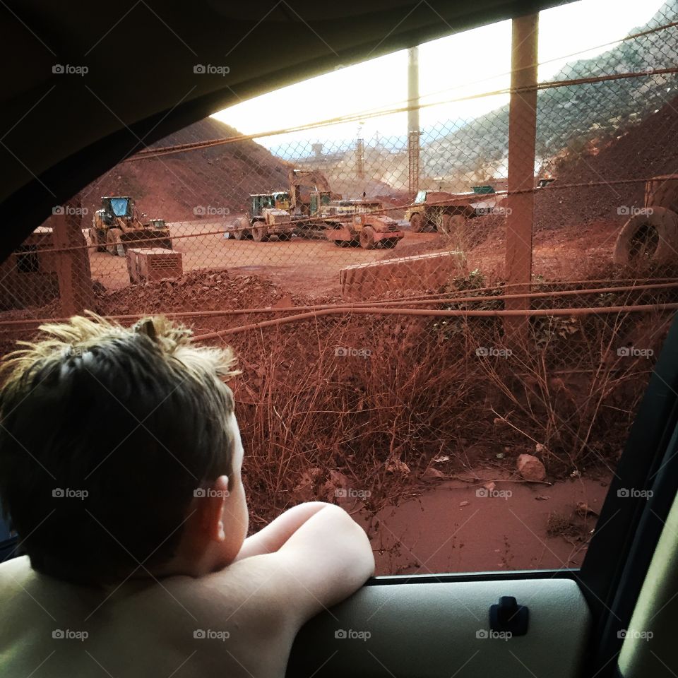 A boy is watching outside cars window