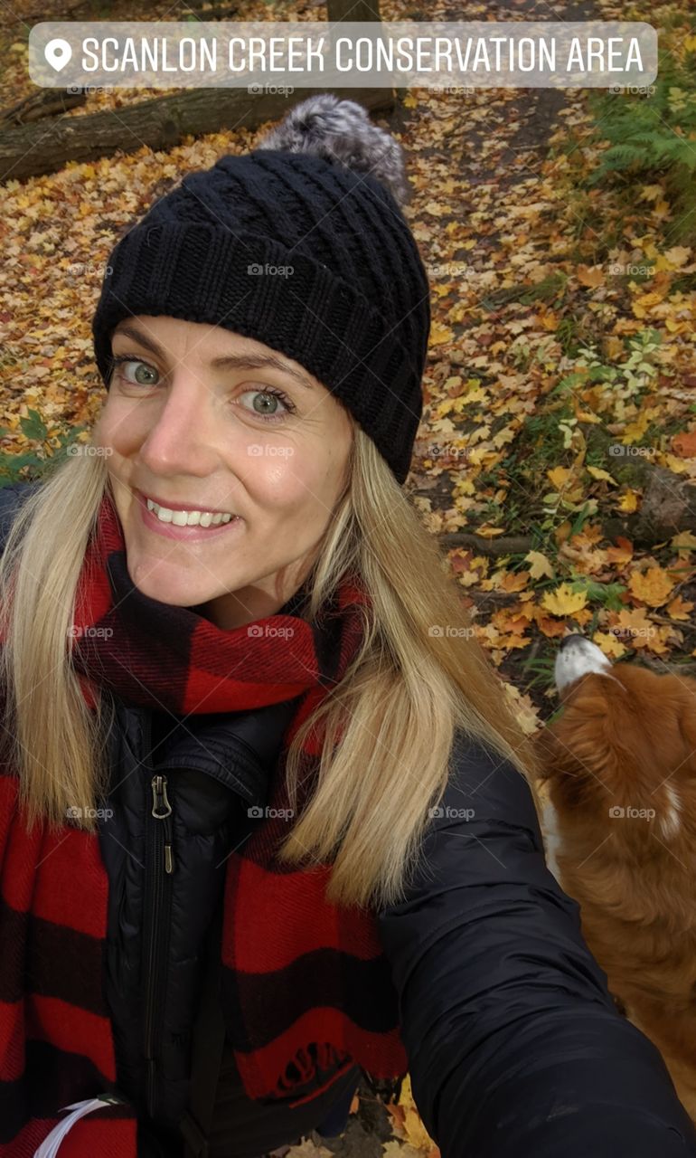 Woman taking a selfie with her dog in autumn