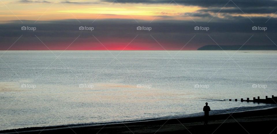 Dramatic winter sunset leaving an area of dark red on the horizon of the English Channel 