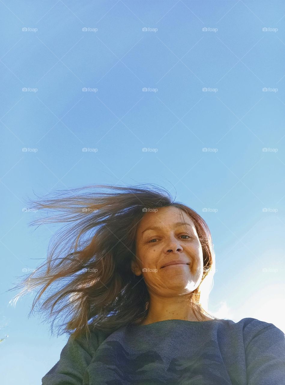 happy woman outside blue sky background