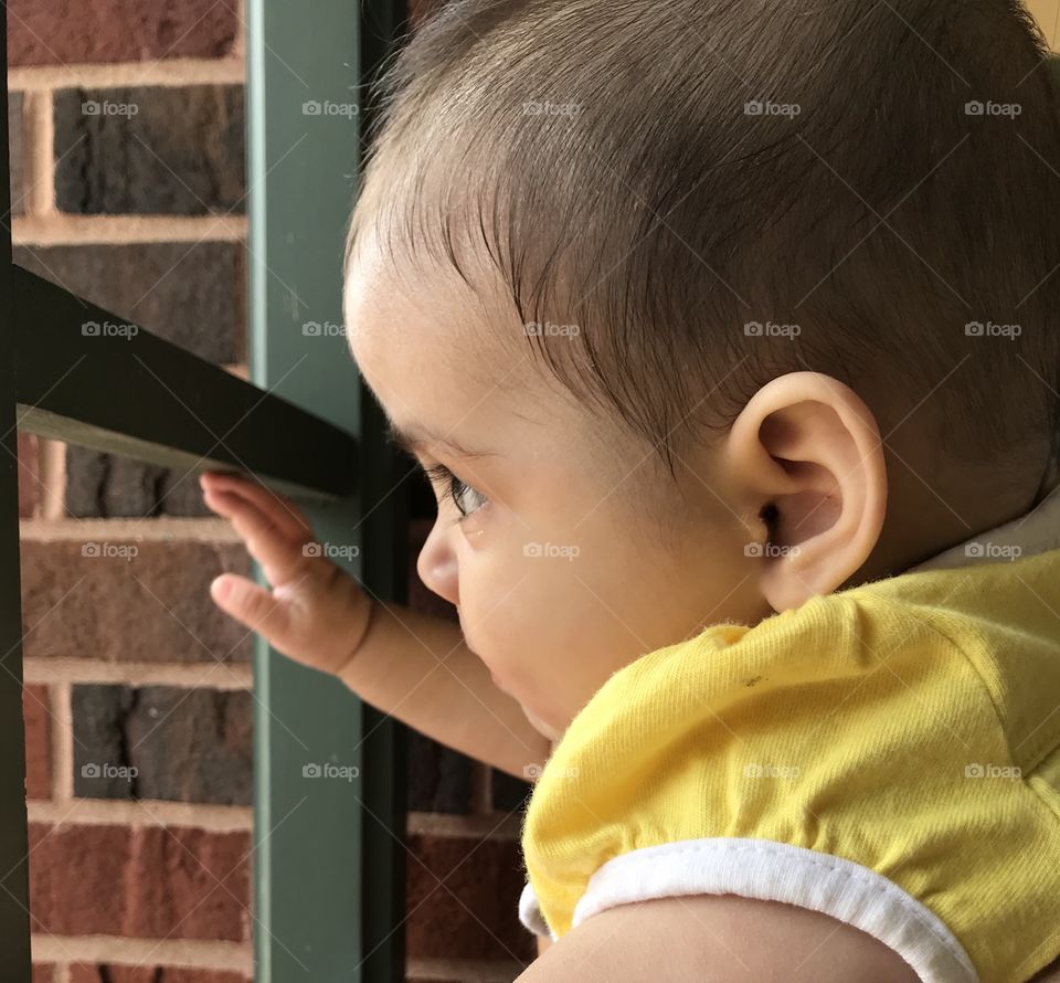 Baby girl looking out window