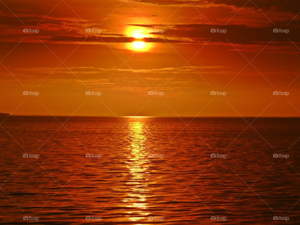 It was sunset. I watched with an unwavering gaze, as a fiery orange orb of light slowly sank beneath the horizon, and threads of light lingered in the sky, mingling with the clouds