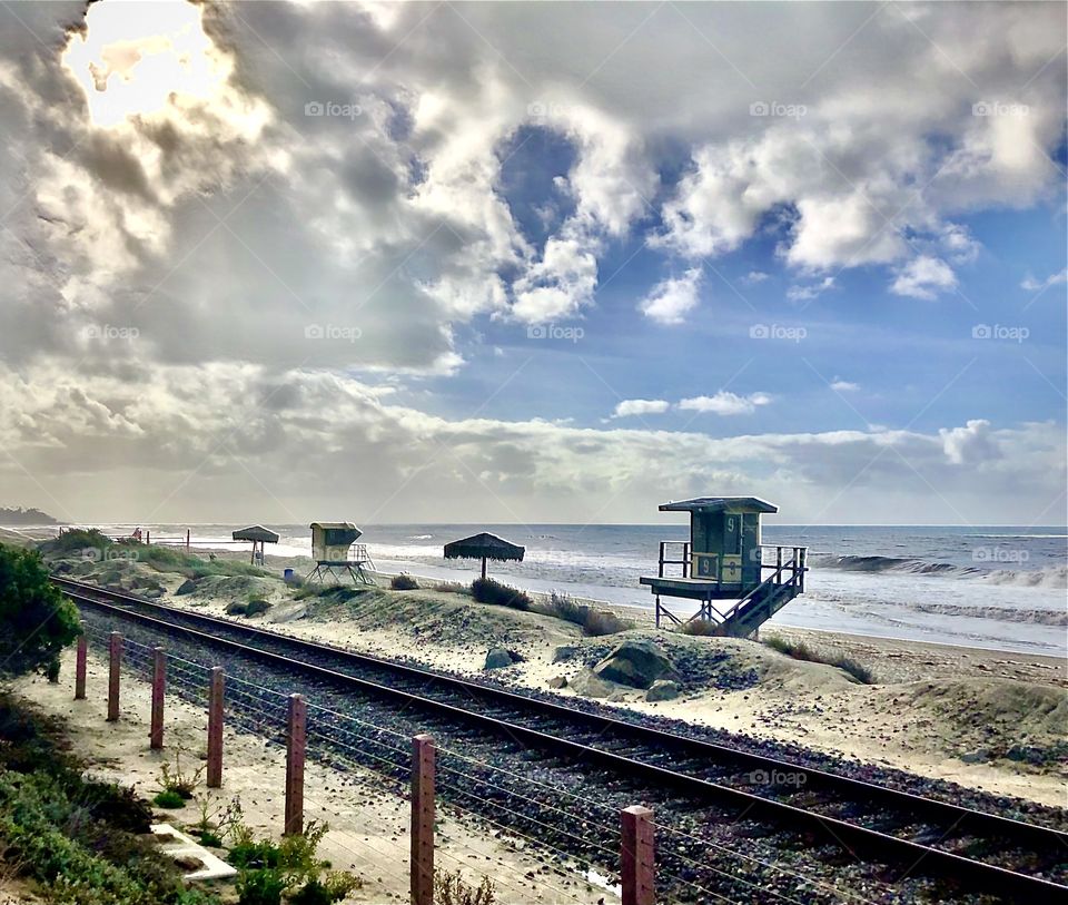 Foap Mission “I Love This Waterscape”! Unique Southern California Coastline, Railroad Tracks, Lifeguard Stand, Palapa Umbrellas, Blue Skies And Billowy Clouds!