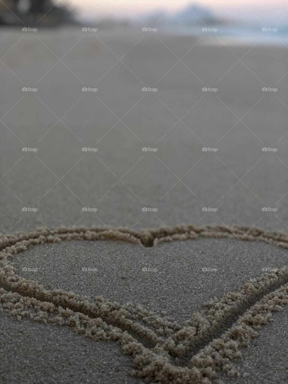 A heart drawn on the sand of a beautiful beach