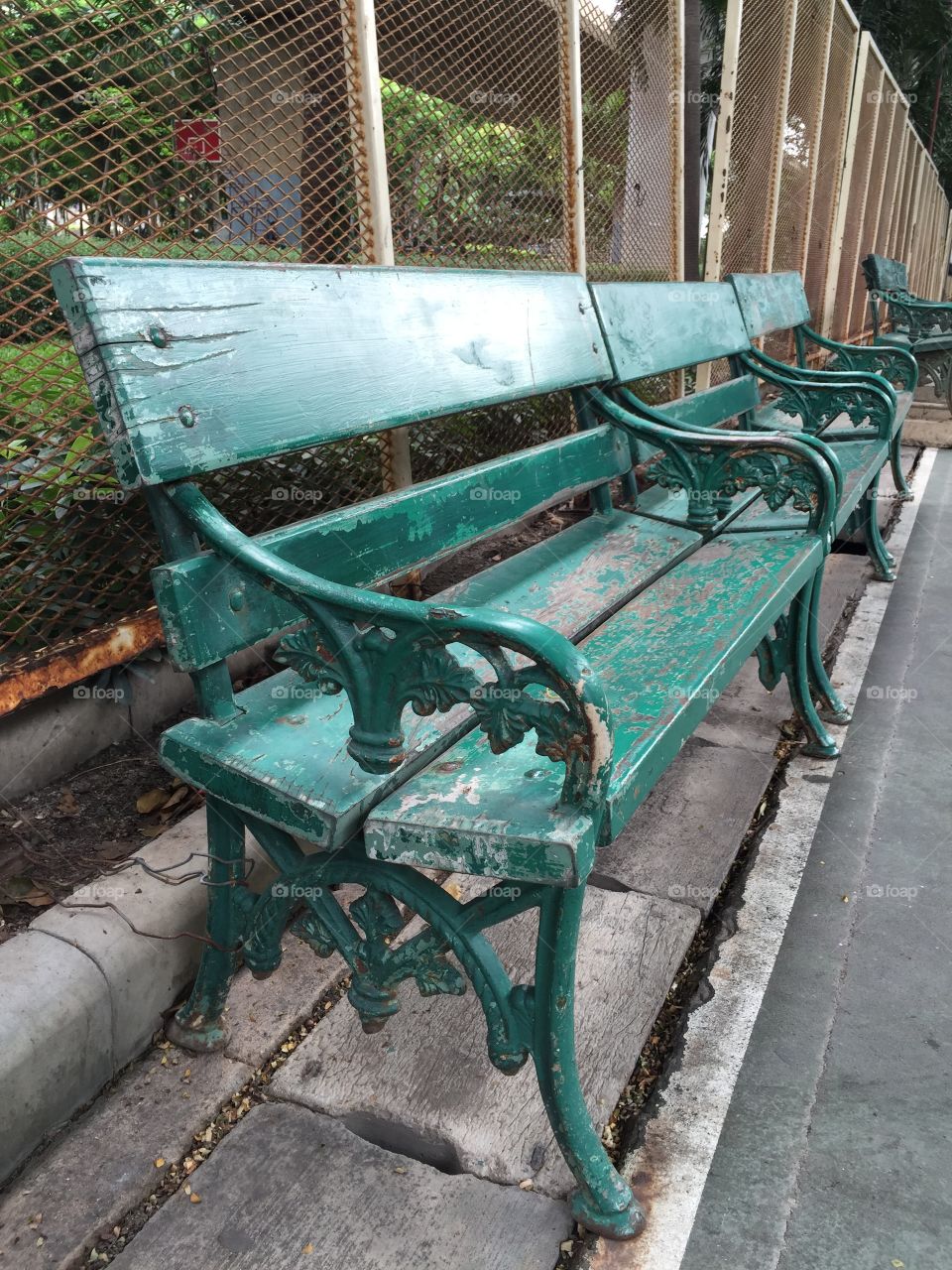 Green bench at the edge of football field.