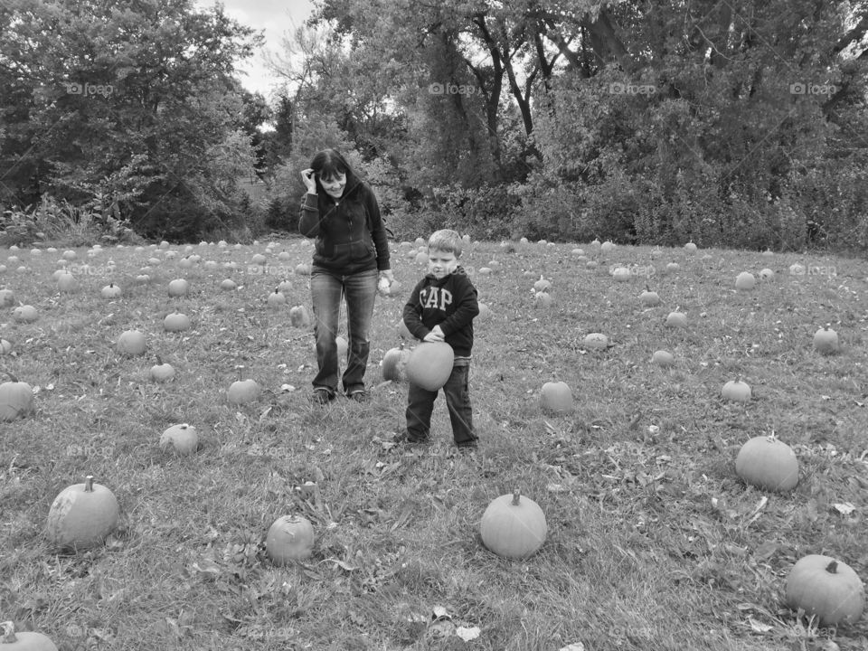 Mother and son standing in pumpkin patch