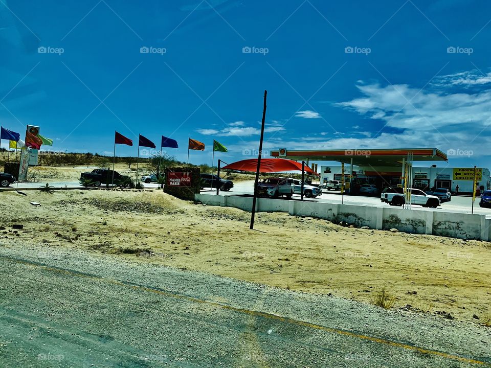 View of a gas station with bright flags colored differently for visibility.