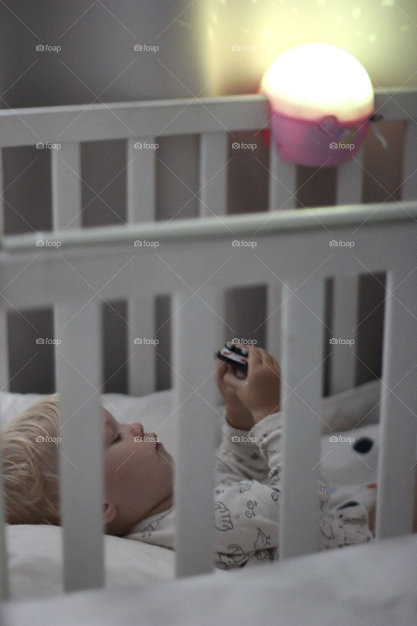 Baby falls asleep in bed with nightlight 