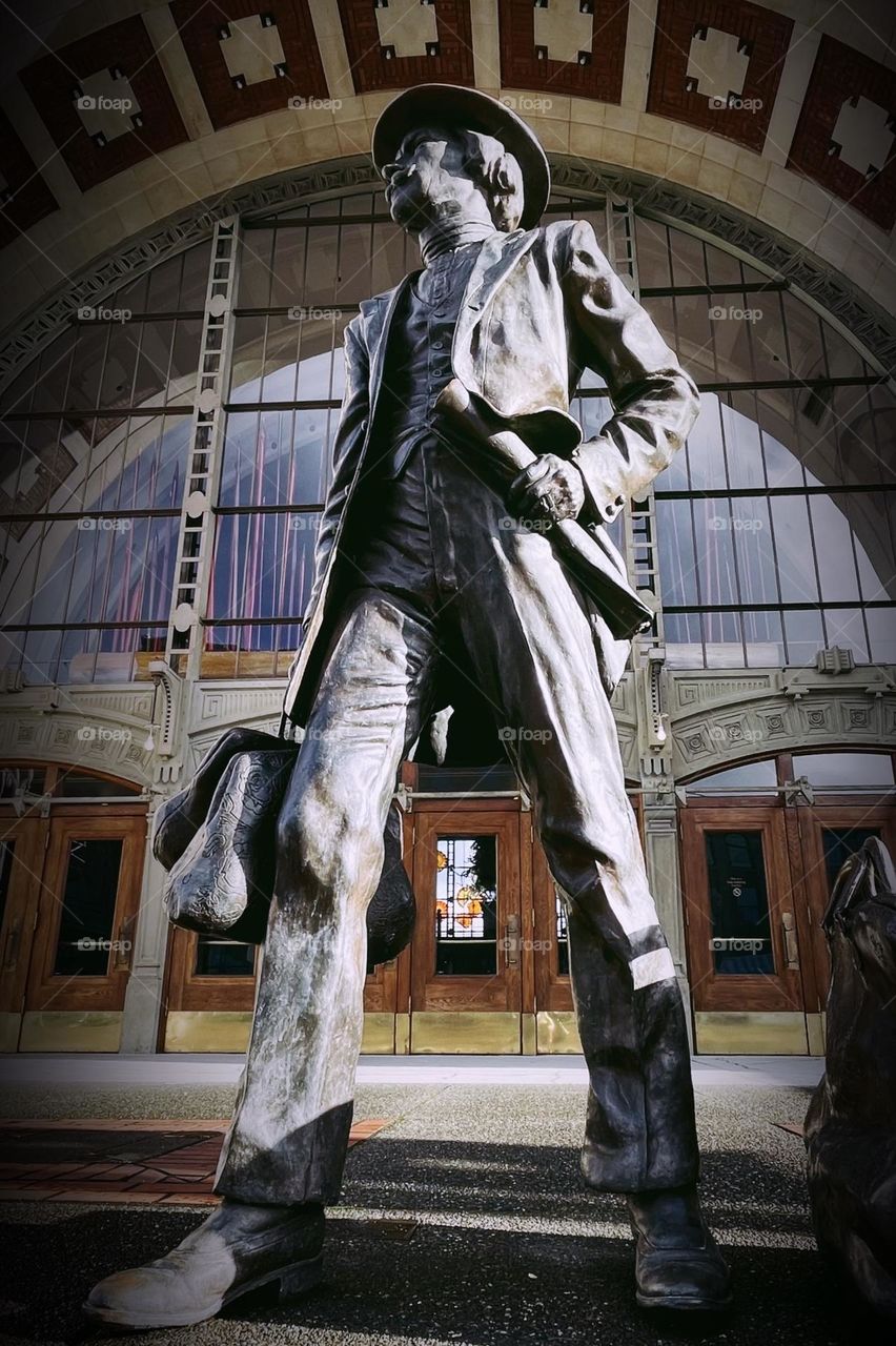 A metal statue of a commuter waiting for the train stands in front of the Tacoma Union Station in downtown Tacoma, Washington 