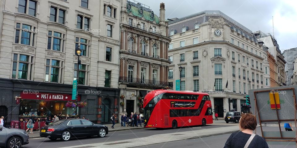 red london bus in front of city buildings