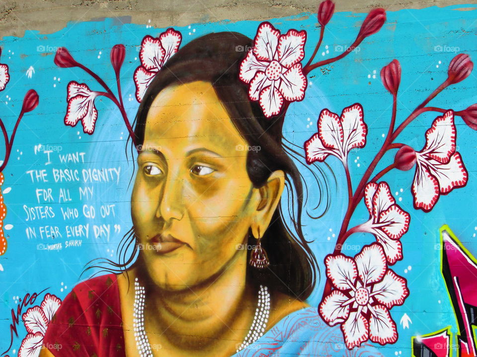 street art of a woman's face surrounded by flowers. ln a Downtown Sacramento alleyway