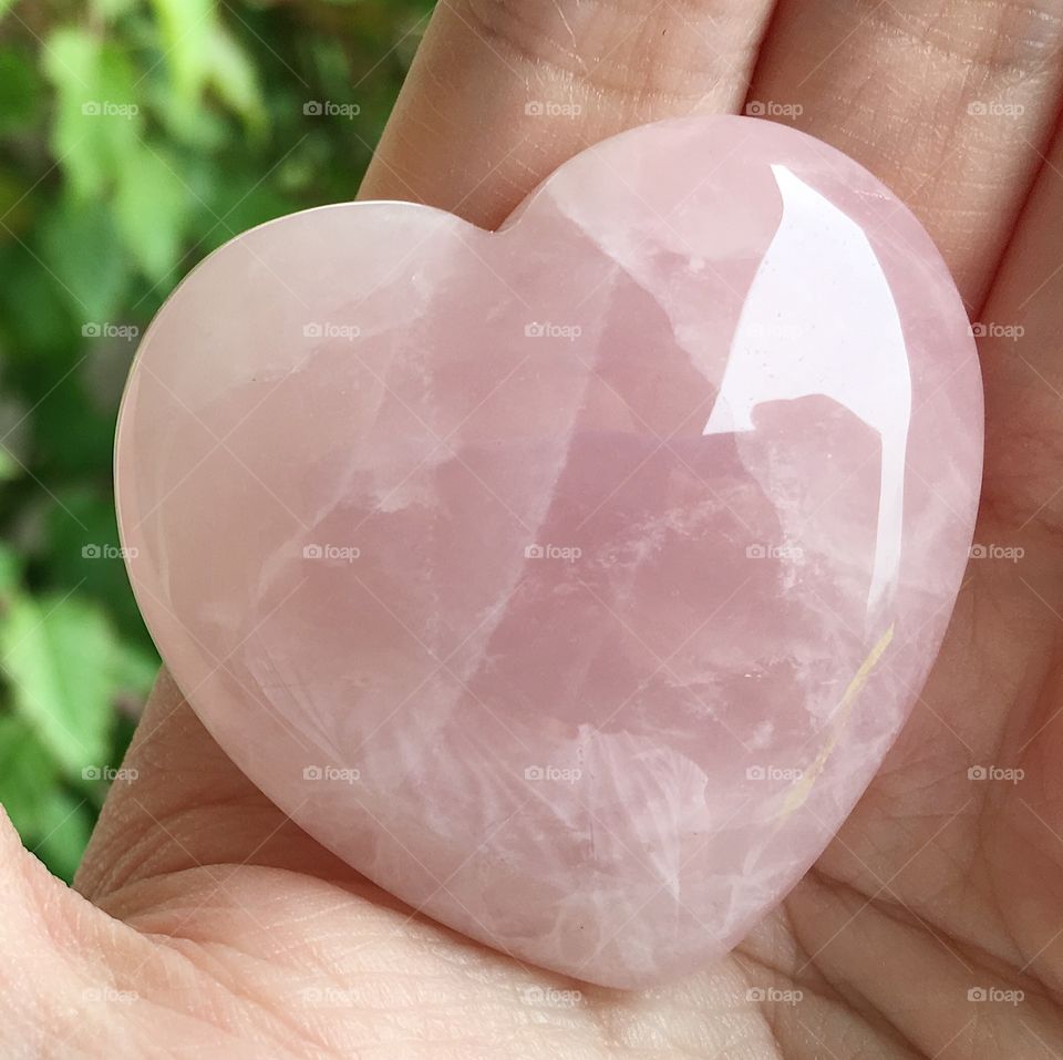 A pink heart-shaped rose quartz crystal.