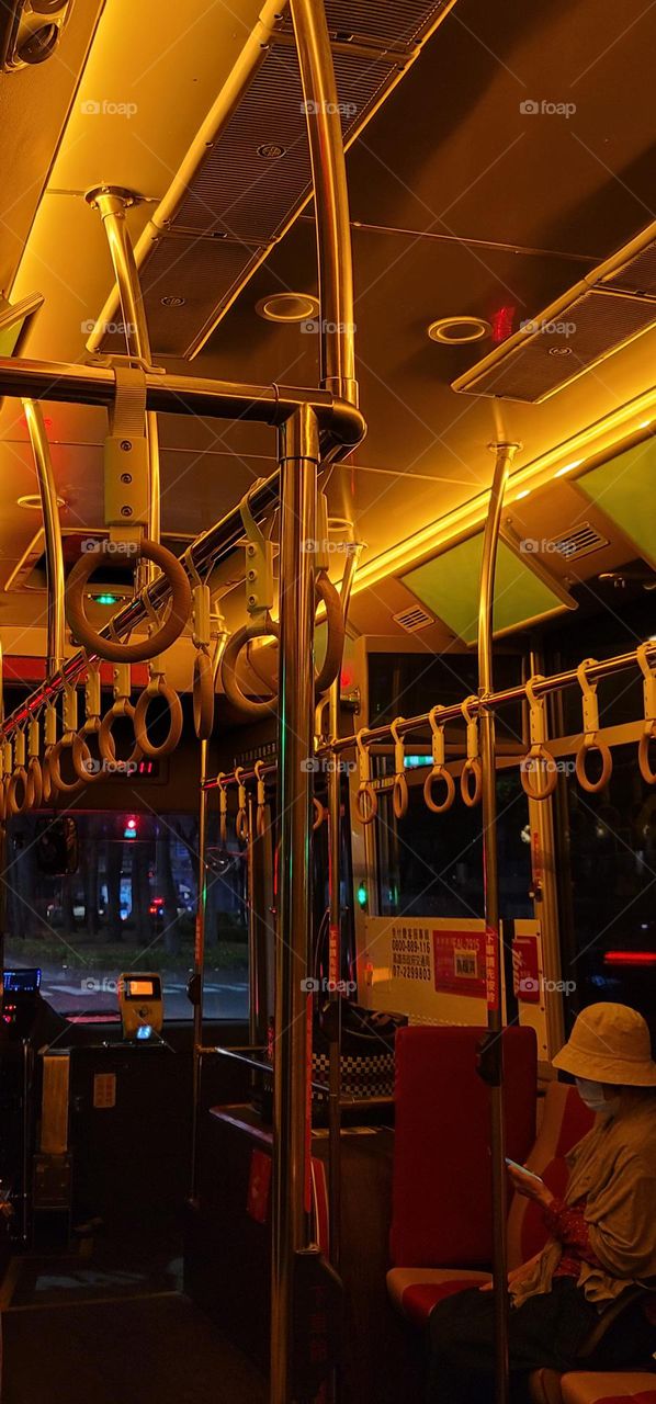 A retro-style bus with a warm yellow light interior.handrail ring.Bus handrail ring.bus seat