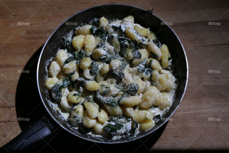 Gnocchi di patate saltati in padella con olio aglio peperoncino spinaci e panna vegetale a fine cottura a piacere pane grattugiato