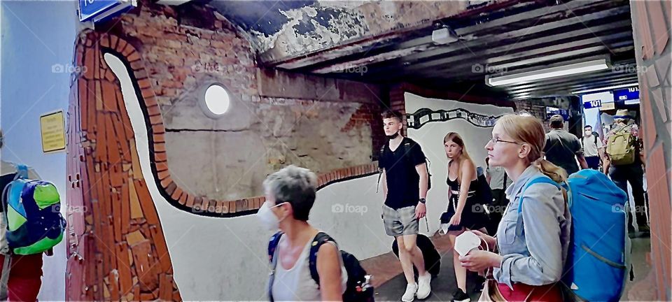 People are emerging from the hallways of this “Bad Ülsten” train station spilling over everywhere on their way to connection trains or out onto the streets. 2022. Hypnotic Productions