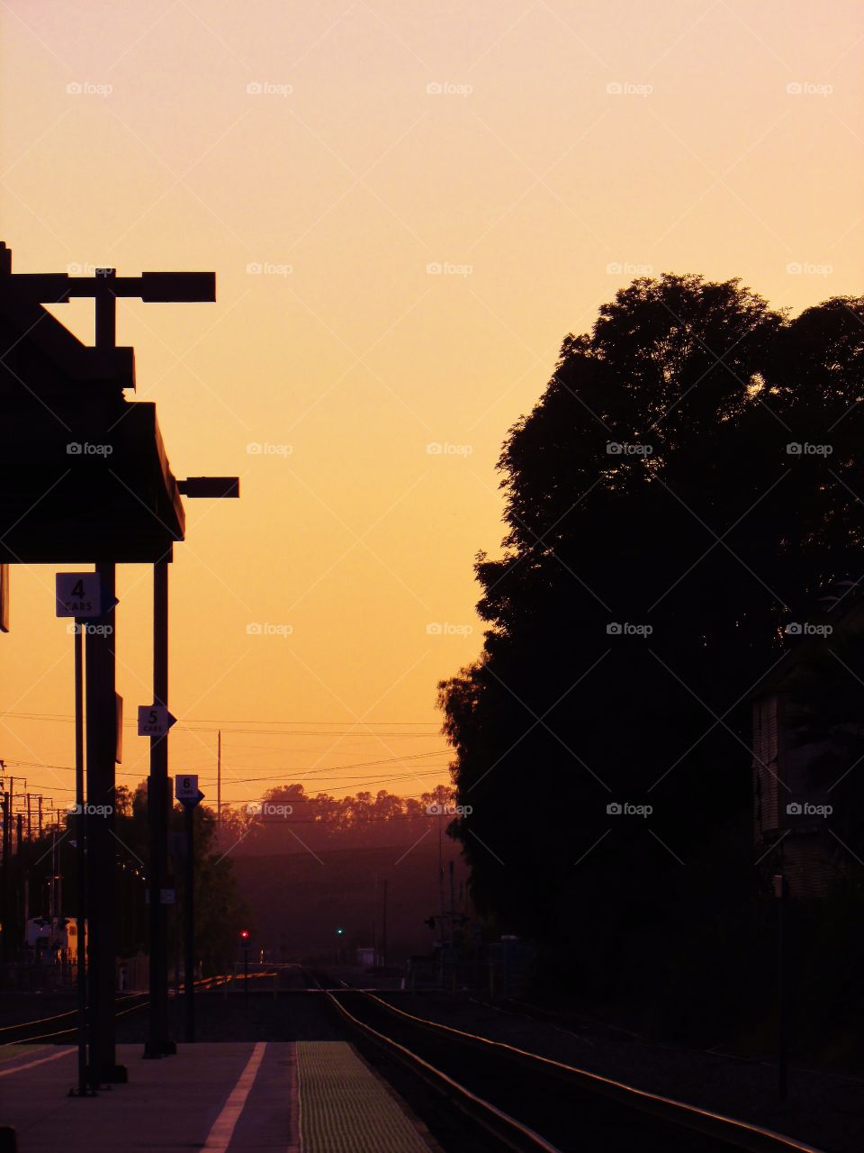 Two signals await the arrival of a Northbound train as the sun sets 