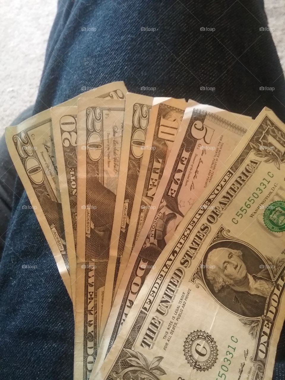save money dollar bills in hand or lap