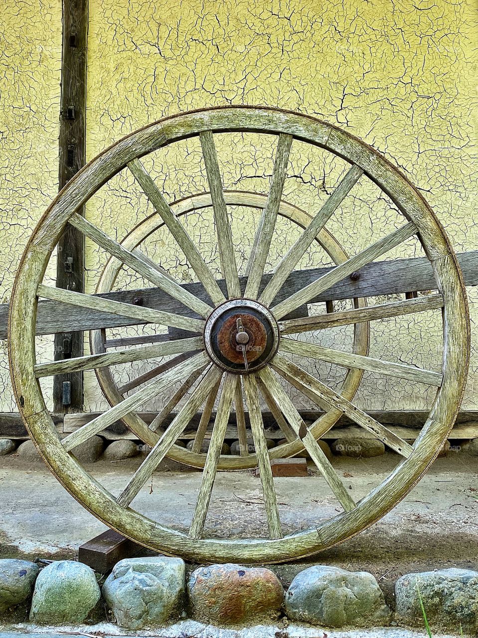 Huge circular wheels on a very old wooden wheelbarrow at a folk house open air museum in Japan.