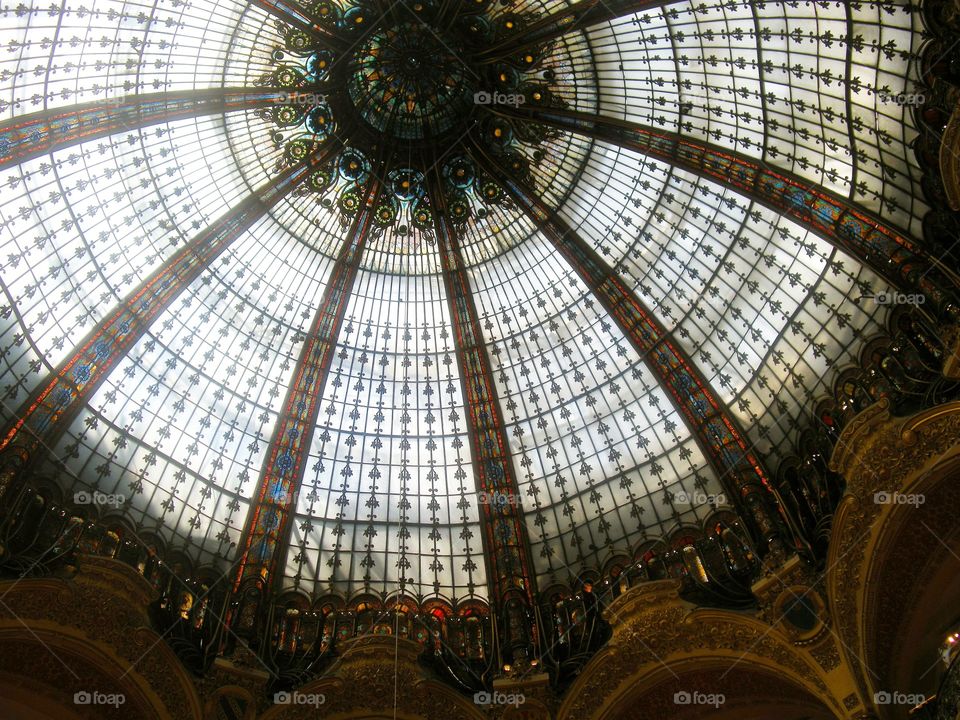 Una enorme cúpula de cristalera de colores en el centro comercial "Galerías Laffaete " envuelve el espectador , invitando a disfrutar de compras con elegancia del centro de París.  Su estructura clásica en negro y dorado le hace soñar .