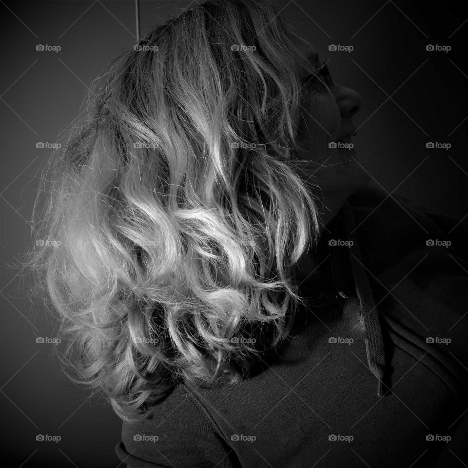 woman showing her curly hair black and white low key picture