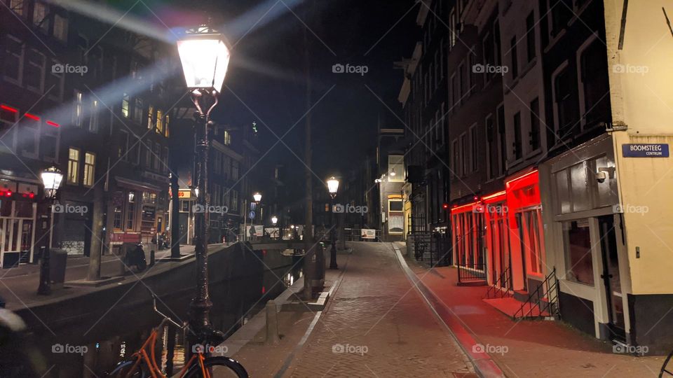 Lonely orange bike in empty red light district (Amsterdam)