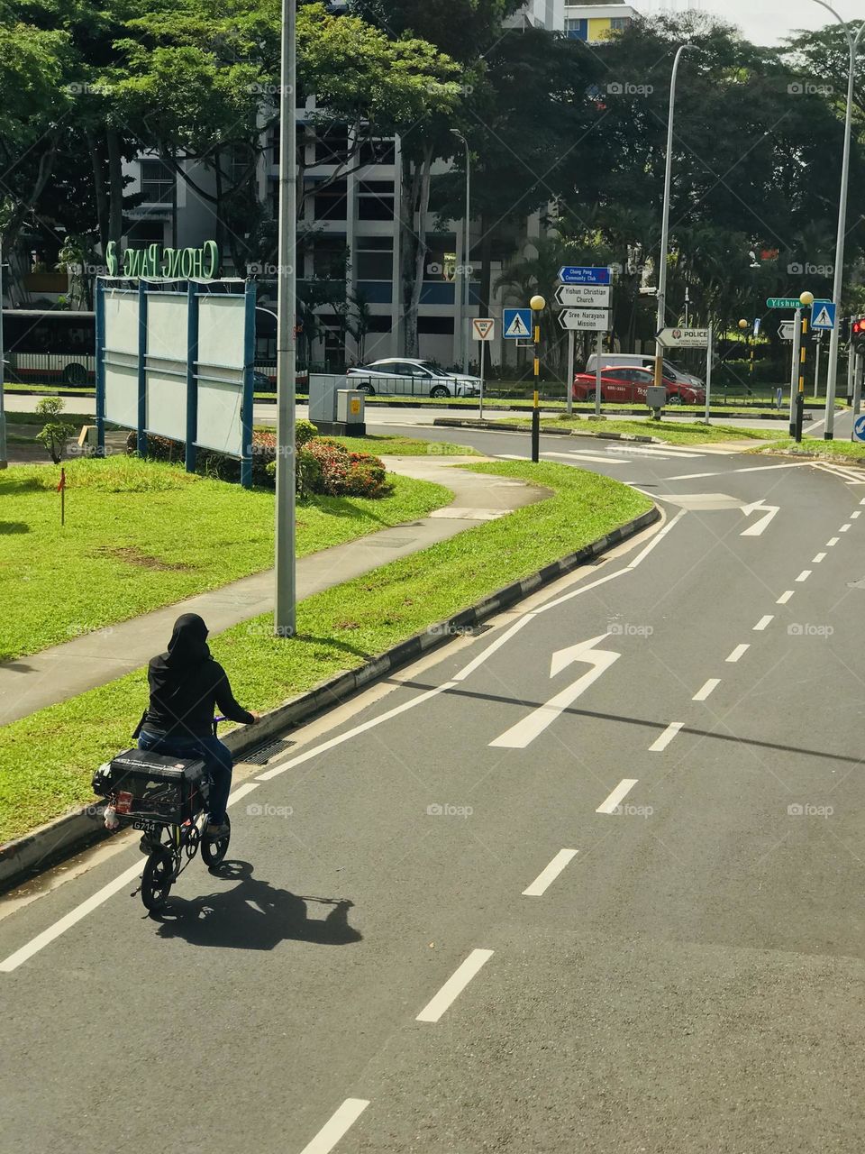 Women going on bicycle on the road and her shadow reflecting on road 