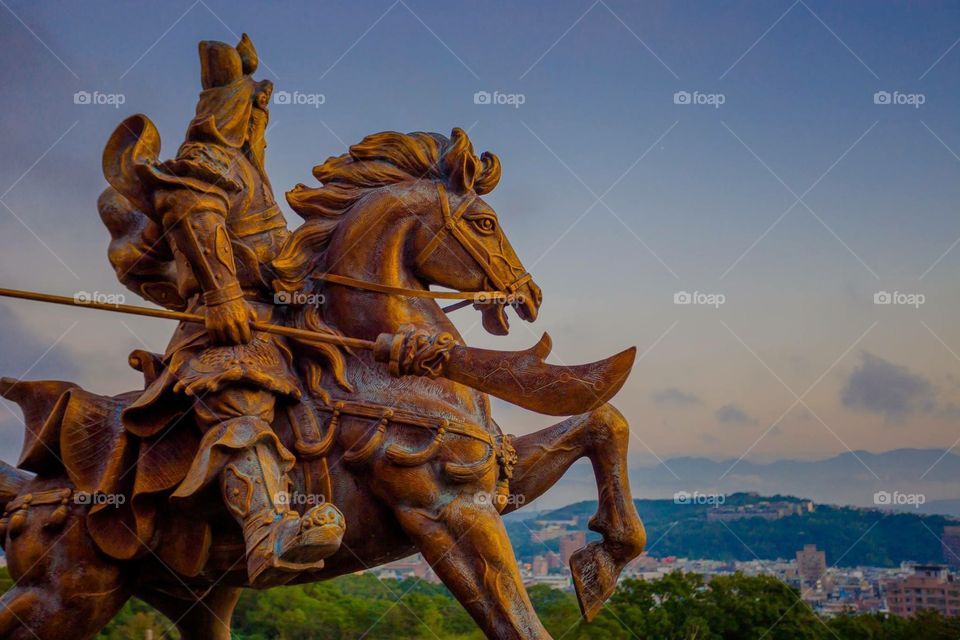 Chinese army commander on horse statue overlooking valet from mountaintop